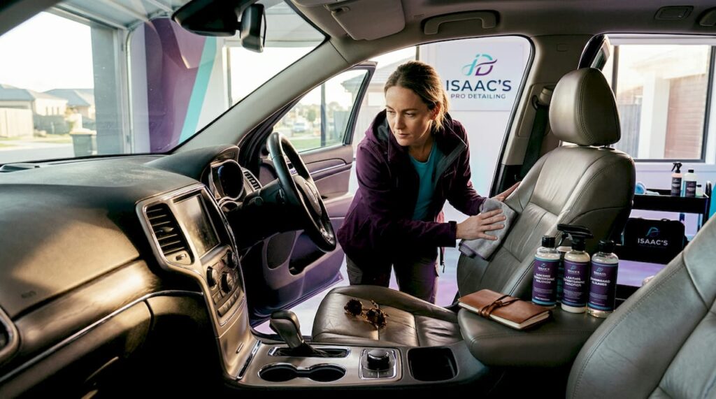 Person cleaning leather car seat interior