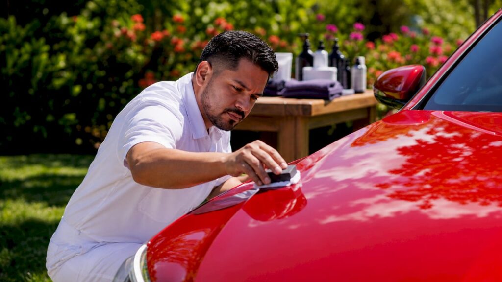 Professional applying ceramic coating to car hood