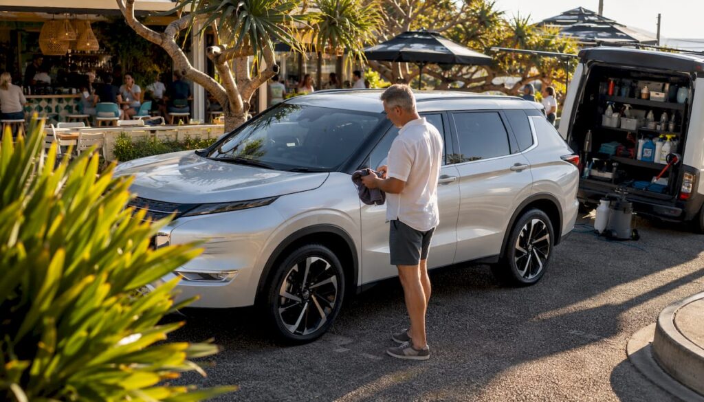 Man inspecting detailed SUV on Sunshine Coast street