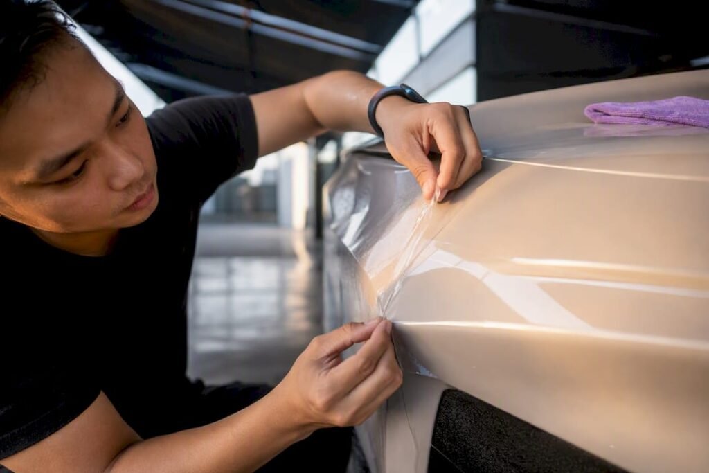 Installer aligning film on a car panel