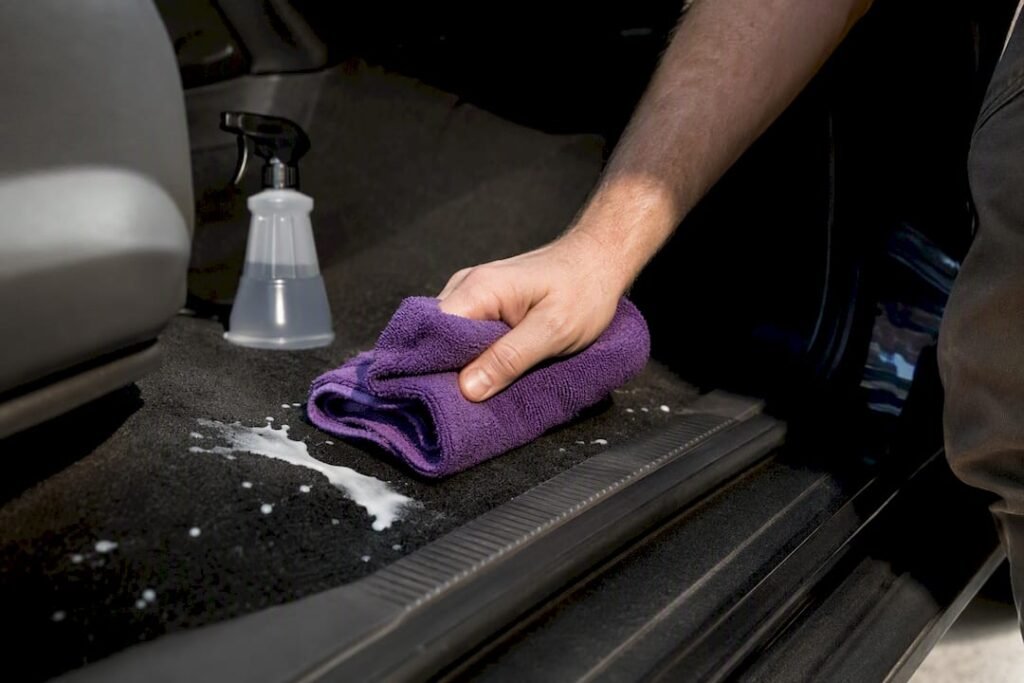 Towel blotting fresh milk from car carpet